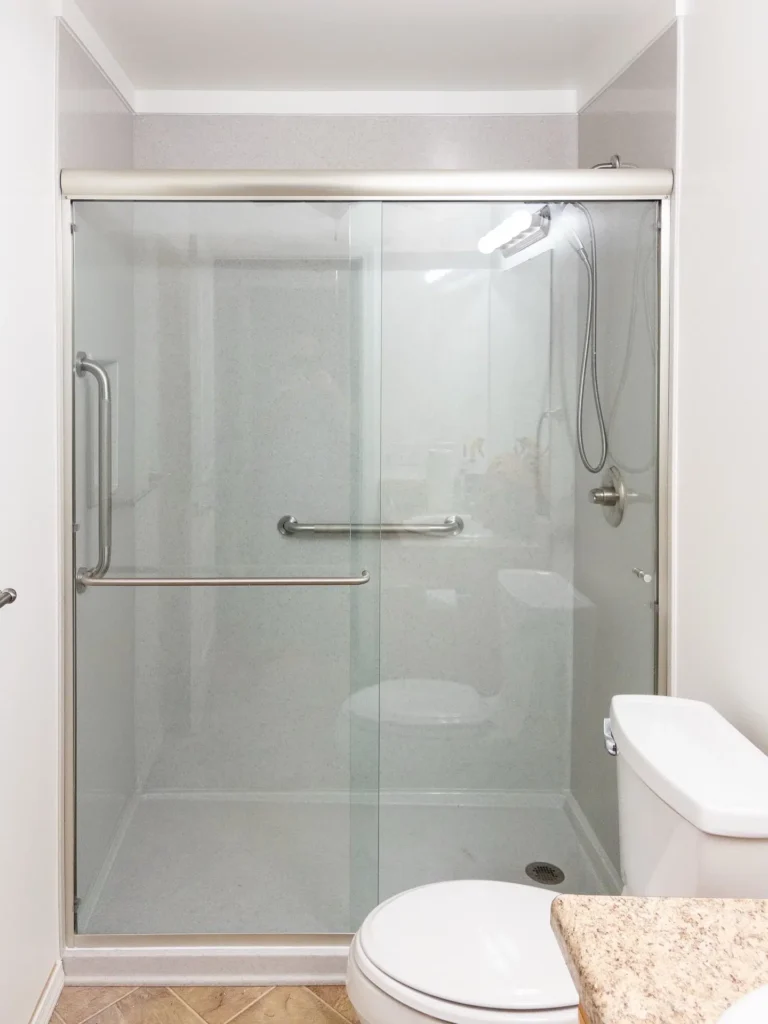 Sliding glass shower door beside a toilet
