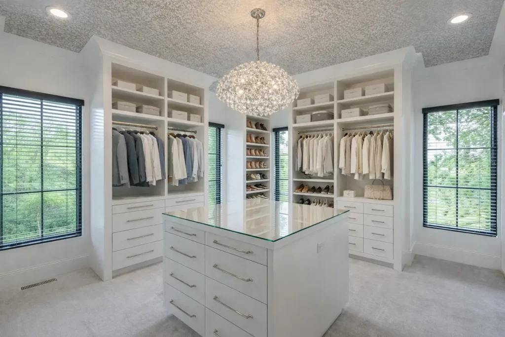 White walk in closet with central island chandelier and surrounding windows